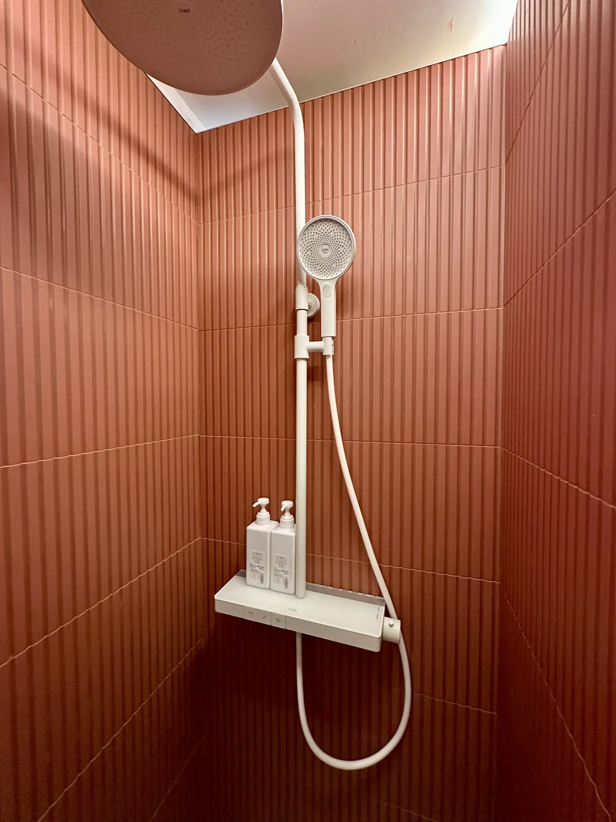 Douche à l'italienne en faïence cannelée terracotta avec colonne de douche